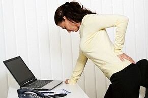 една жена има болки в гърба в лумбалната област